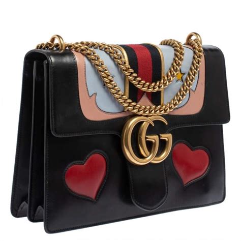 black gucci purse with heart.